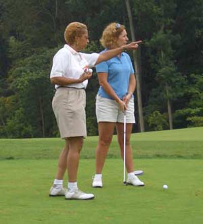 Barbara Danforth instructing a woman at the YWCA- Ohio Womens Bar Association Golf Outing